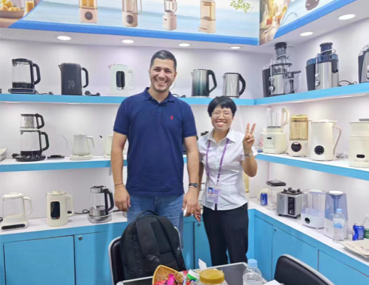 Zhongshan Yuekon Electrical Appliances Co., Limited 팀원과 국제 고객이 단체 사진을 찍기 위해 웃고 있는 이미지는 긍정적인 비즈니스 상호 작용을 반영합니다.